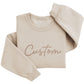 A beige sweater with the word "Custom" printed on it.