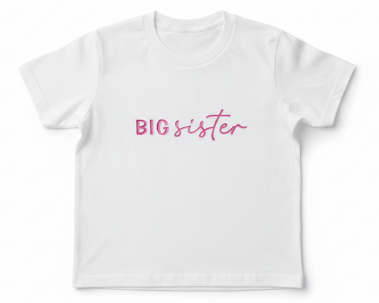 A white T-Shirt with "Big Sister" embroidered on the front in pinkthread