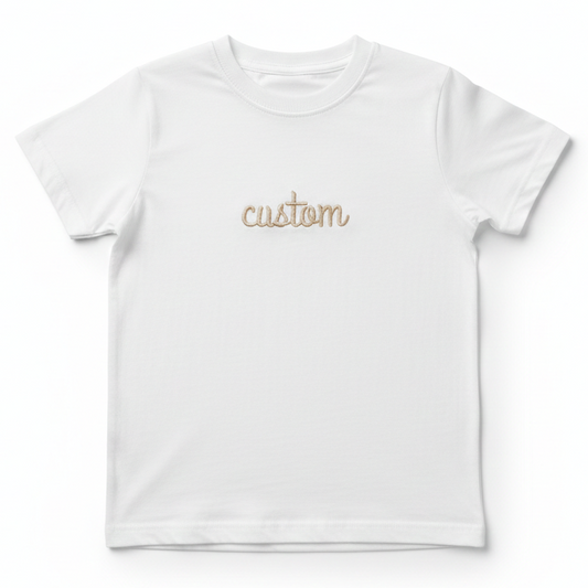 A white T-Shirt with the word "custom" embroidered on the front in gold thread